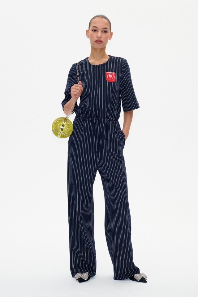 Jordyn Jumpsuit Tracksuit Pinstripe This stretchy jumpsuit features a zipped placket in the front, a drawstring at the waist, and pockets at the sides and back - model image