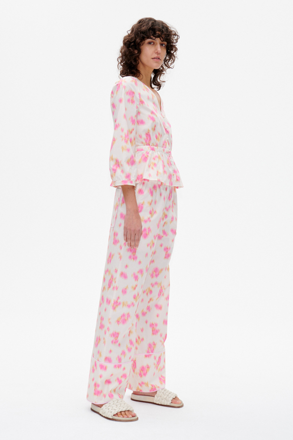 Nala Trousers Pink Fleur Fanee These high-rise, wide-leg soft trousers feature an elasticated waistband, side pockets, and a pocket at the back - model image