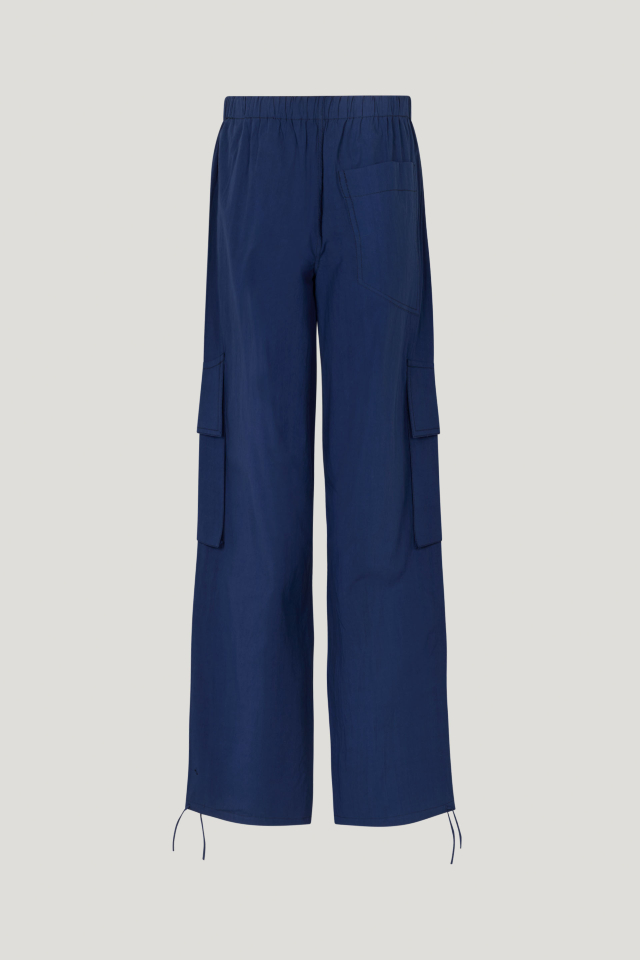 Nasra Trousers Ocean Cavern These trousers feature a mid-rise, elasticated waistband, side and cargo pockets, and drawstring ties at the ankles - back image