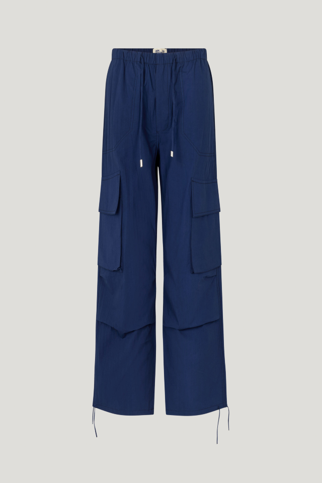 Nasra Trousers Ocean Cavern These trousers feature a mid-rise, elasticated waistband, side and cargo pockets, and drawstring ties at the ankles - front image