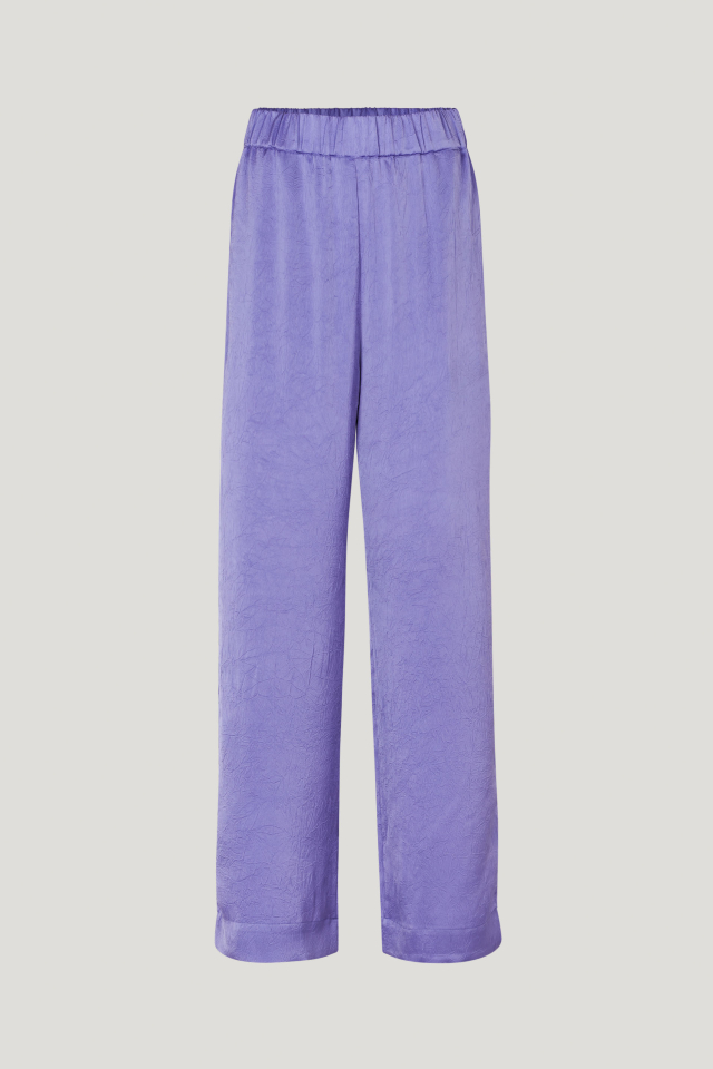 Narine Trousers Dahlia Purple These fluid, wide-leg trousers feature an elasticated waistband, side pockets, and raised seams down the sides - front image