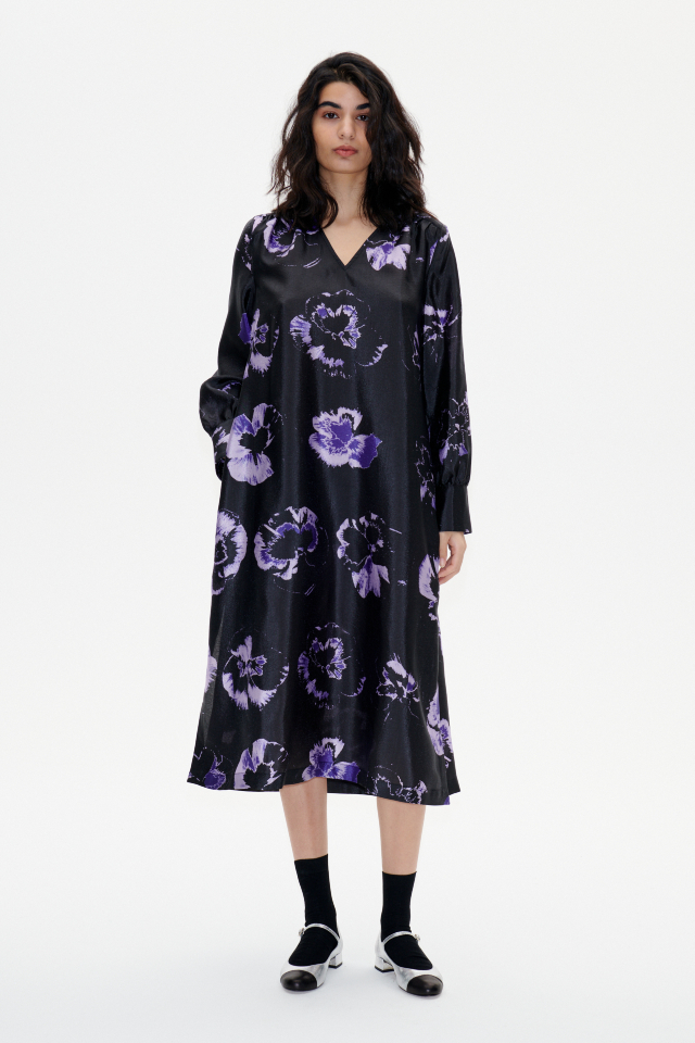 Aradina Dress Purple Pansy This midi-length dress has a removable tie at the waist, side pockets, V-neck, and cuffed sleeves - model image