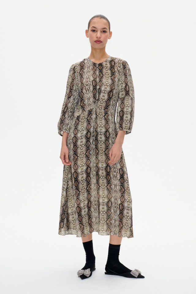 Adya Dress Light Yellow Snake This midi-length dress features cropped sleeves, a button closure with keyhole opening at the neck, and a pleat in the middle for a flattering drape - model image