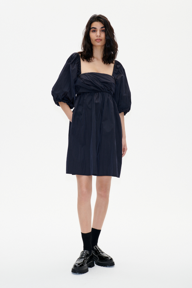 Aditi Dress black This babydoll-style nylon dress feaures a zip closure at the side, elasticated shoulders and sleeves, and pockets at the sides - model image