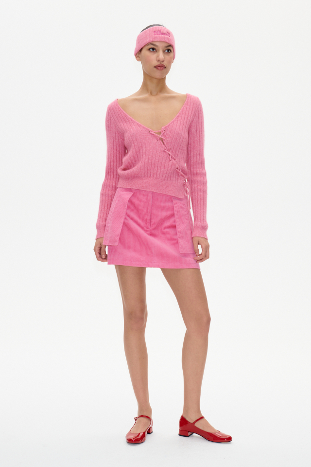 Chelsie Sweater Chateau Rose This soft knit jumepr features a deep V-neck, ribbed pattern, and an asymmetrical lace-up tie in the front - model image