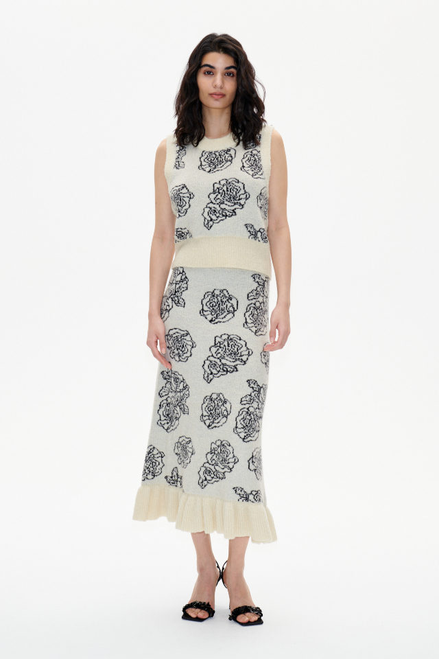 Cinnamon Skirt Creme Embroidery Flower This stretchy, knit mid-calf length pencil skirt has an elasticated waistband and a frill at the hem - model image