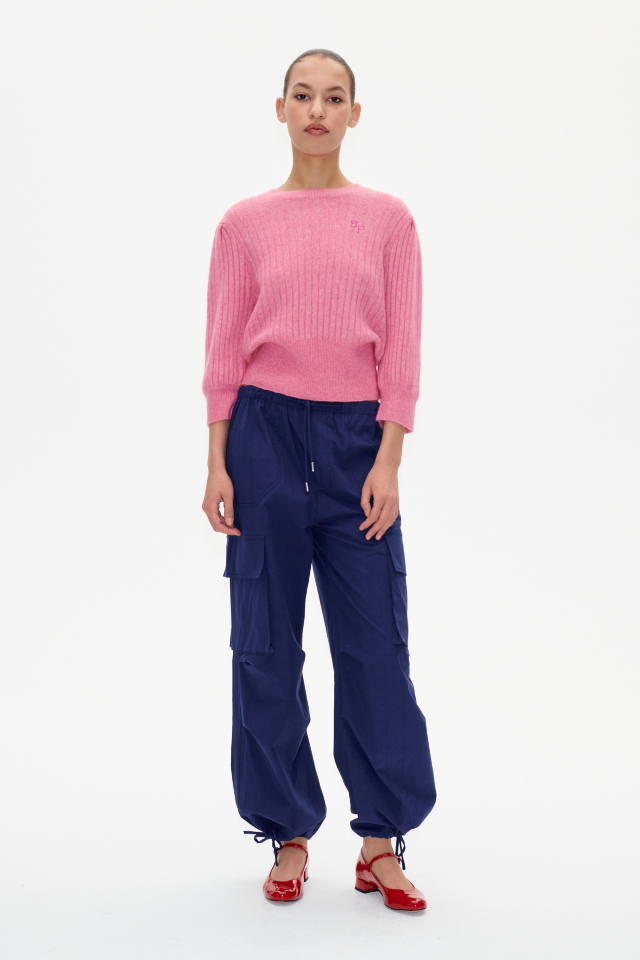 Nasra Trousers Ocean Cavern These trousers feature a mid-rise, elasticated waistband, side and cargo pockets, and drawstring ties at the ankles - model image
