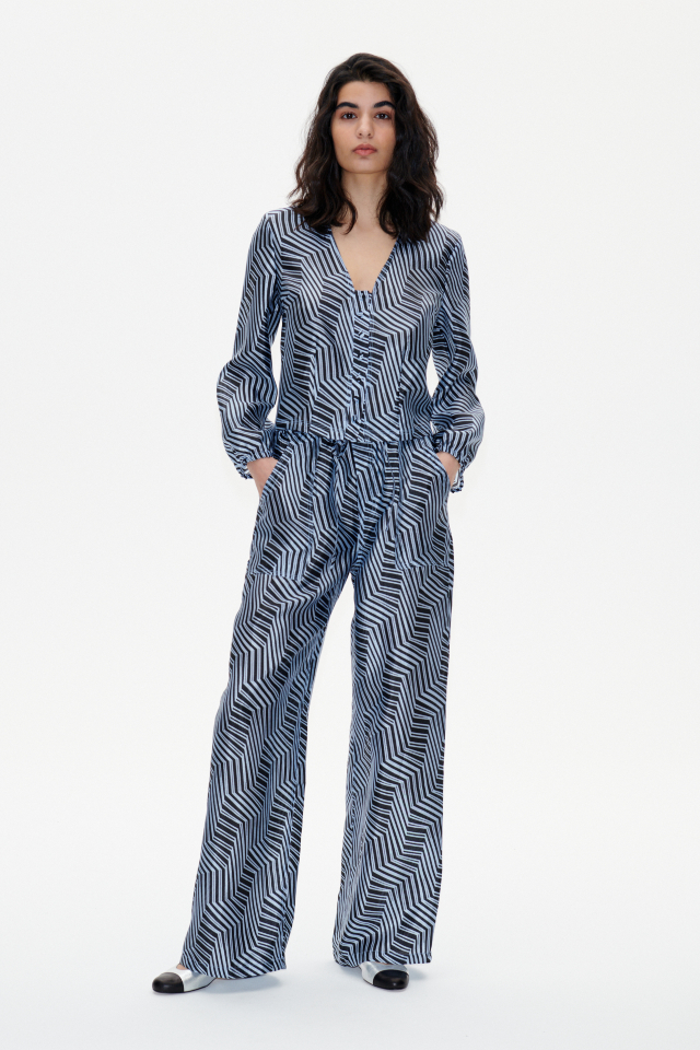 Neddie Trousers Blue Zebra These soft, high-rise trousers feature an elasticated waistband, drawstring tie at the waist, side pockets, and back pockets - model image